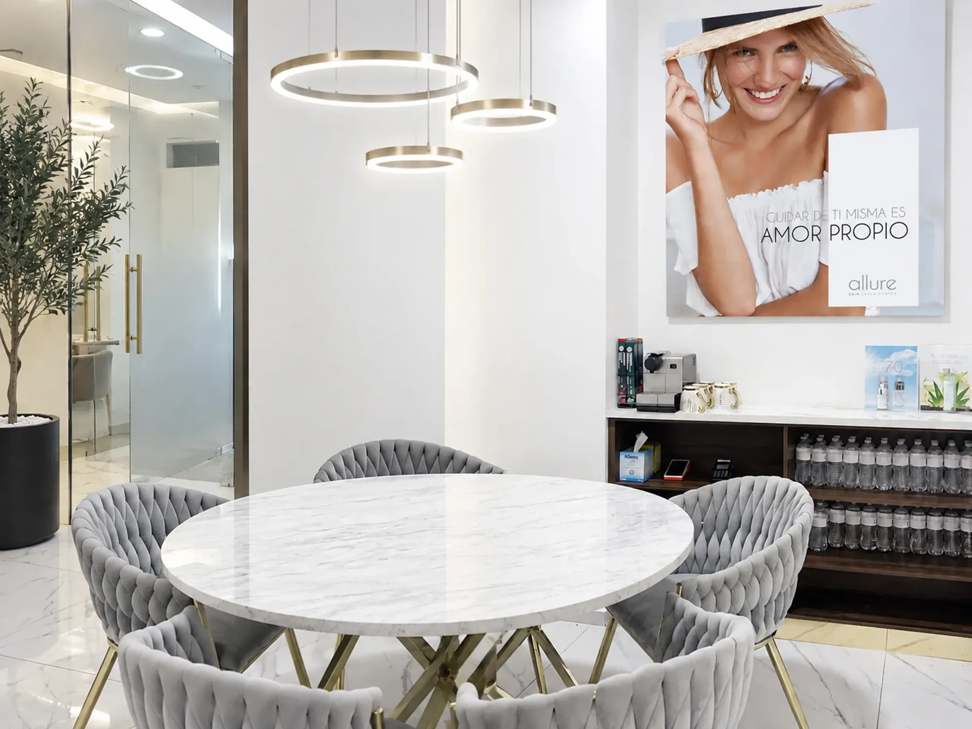 Sala de espera de Allure Skin con mesa de mármol y lámparas doradas